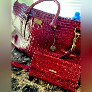 Burgundy Brahmin weekender and matching wallet. Has duster and strap.
